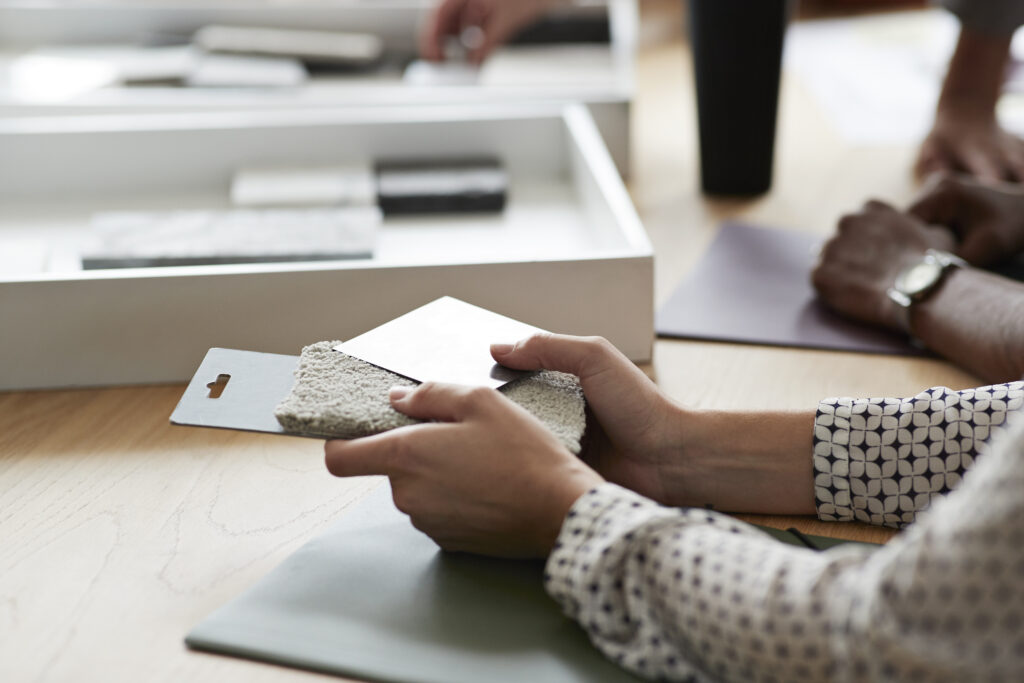 Cropped image of female entrepreneur holding samples over table in office