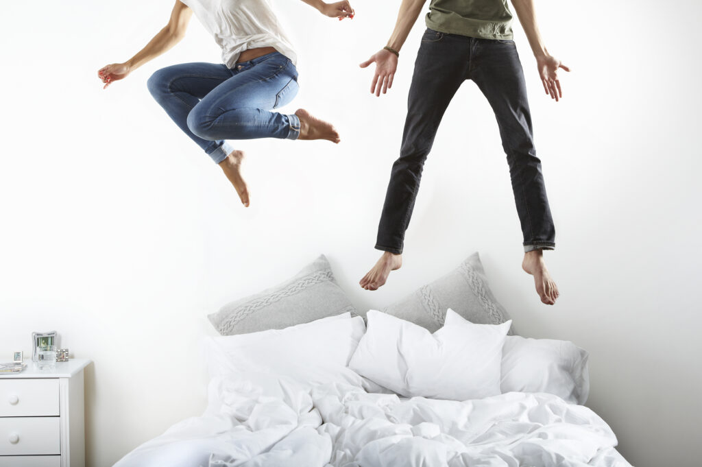 couple jumping on bed