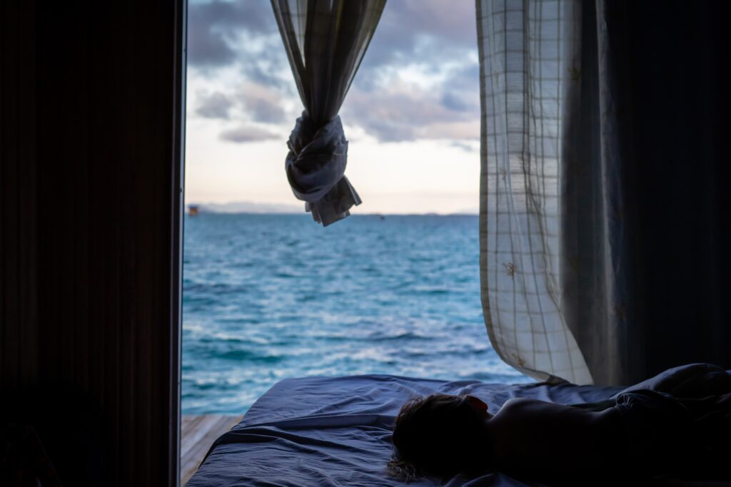 Bedroom with ocean view, with someone sleeping on the bed