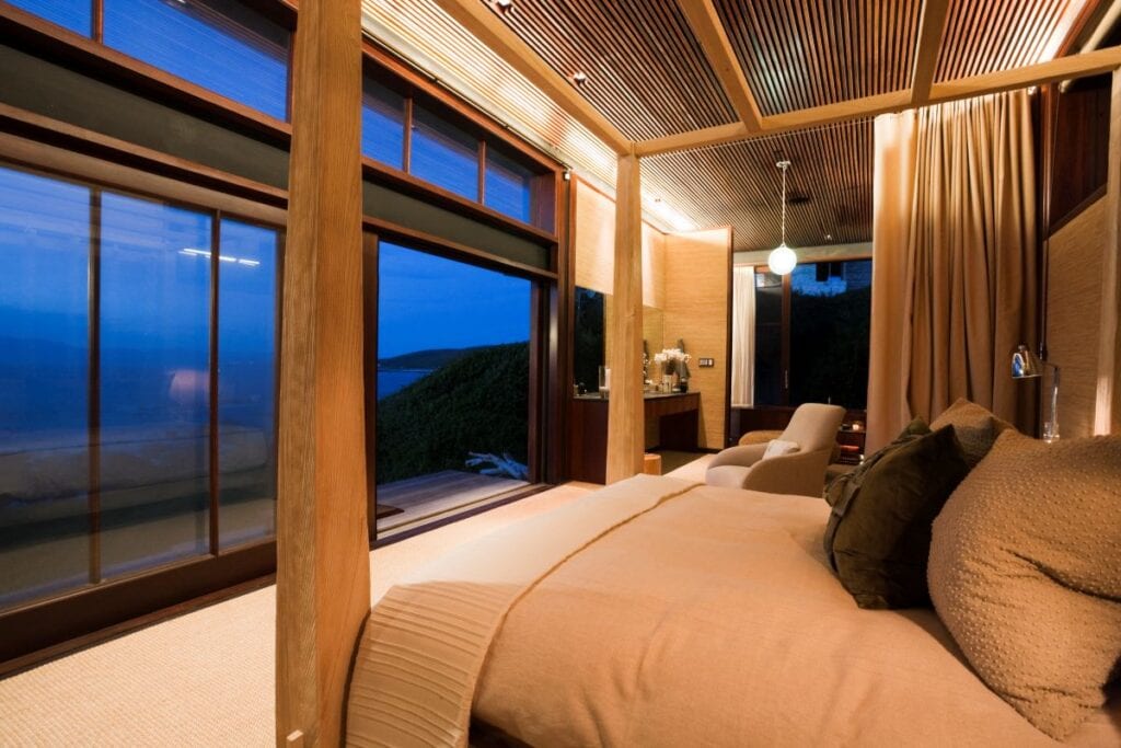 Luxury master bedroom with panoramic ocean view at night