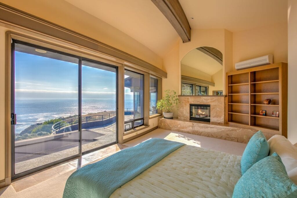 Beautiful master bedroom with fireplace and wide open ocean view