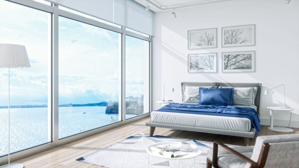 Modern bedroom with floor to ceiling windows and wide ocean view