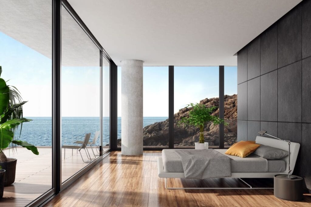 Modern luxury bedroom with black stone wall and wide open ocean view