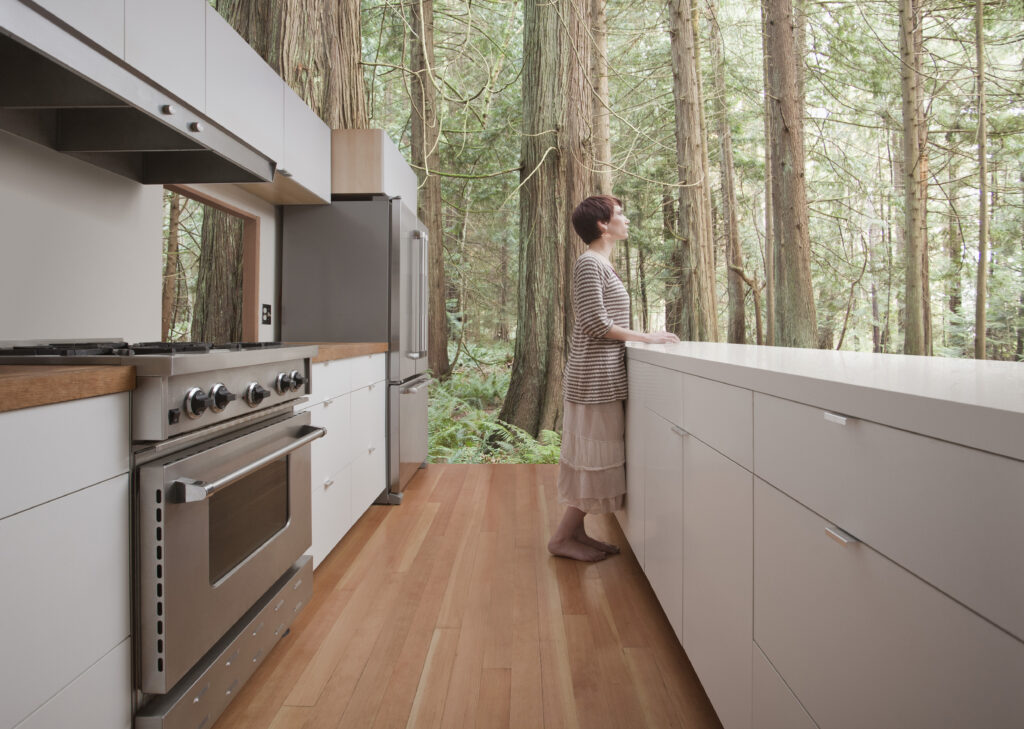 Woman standing in kitchen in forest