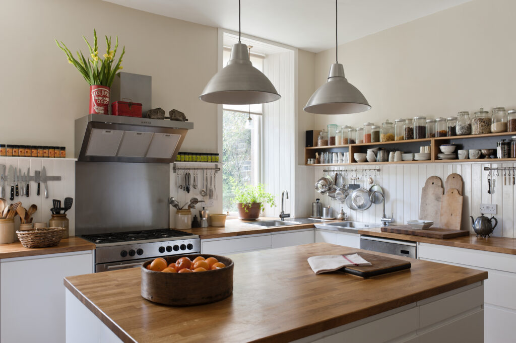 Spacious kitchen with open shelving and solid oak work surfaces. The pendant lights and units are both by Ikea