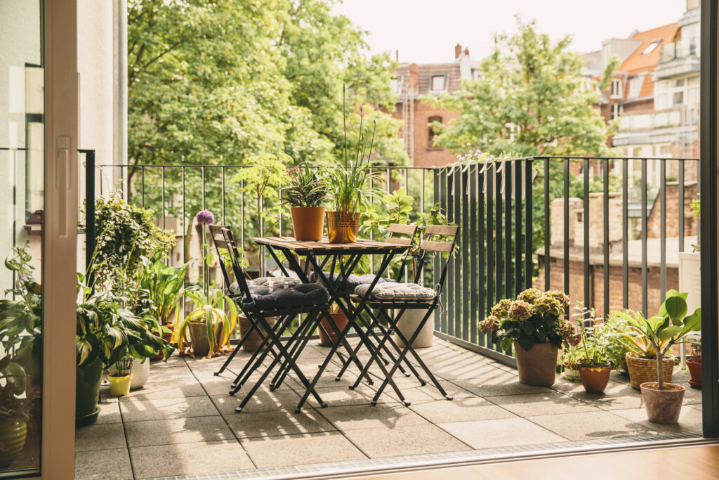 Balcony loggia in summer’s bloom with bistro chairs and a view in the yard, Cologne, NRW, Germany