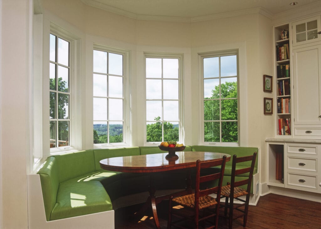 Sunny breakfast nook with green banquette seating