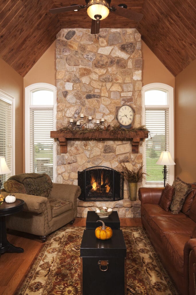 Beautiful addition in a residential home. A four season porch with floor to ceiling stone fireplace, hardwood ceiling and flooring, and arched windows.