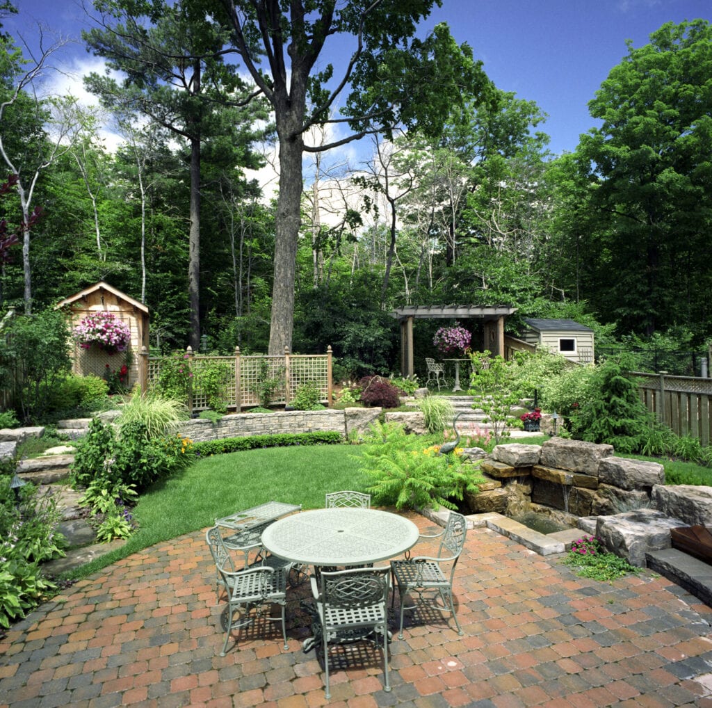 Backyard garden with patio terrace and water feature.