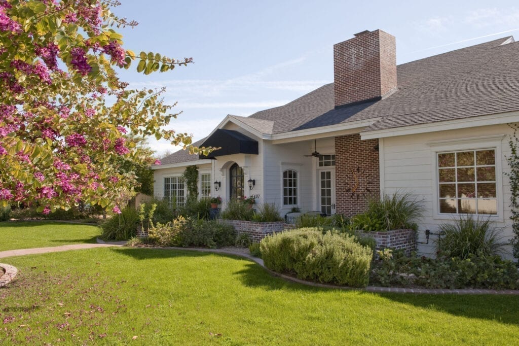 exterior of midsize ranch home on tree line street