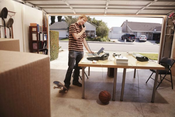 Man talking on phone in office space in garage