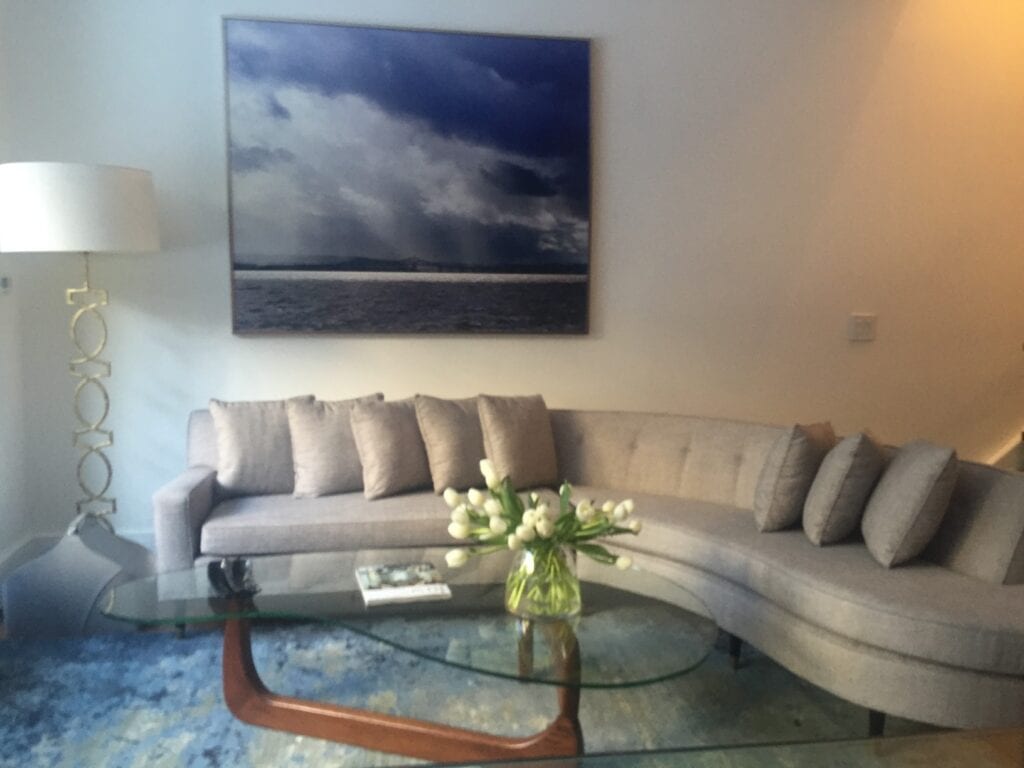 grey sectional with flowers on glass coffee table