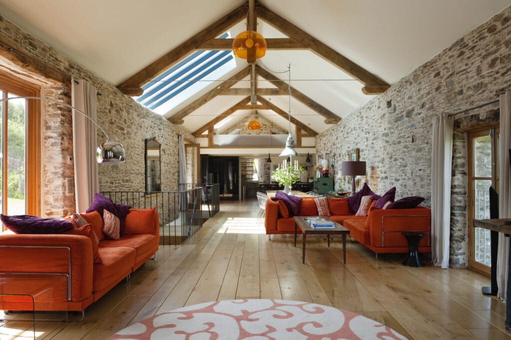 18th century Devon long barn conversion with L-shaped seating unit from Ikea on mezzanine floor