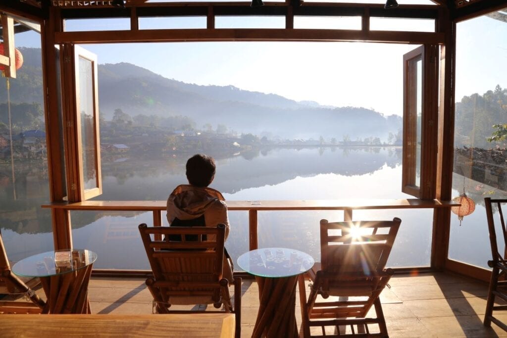Open window with panoramic view of lake and mountains in Thai Mueang, Thailand