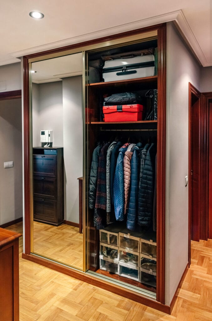 Built-in wardrobe open with mirror doors in the corridor of an apartment