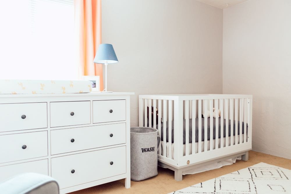 Multifunctional nursery, white crib and dresser that is used as a changing table