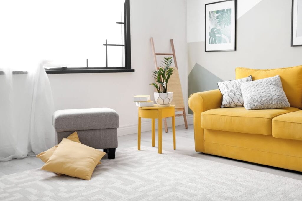 Stylish living room with yellow sofa and accents