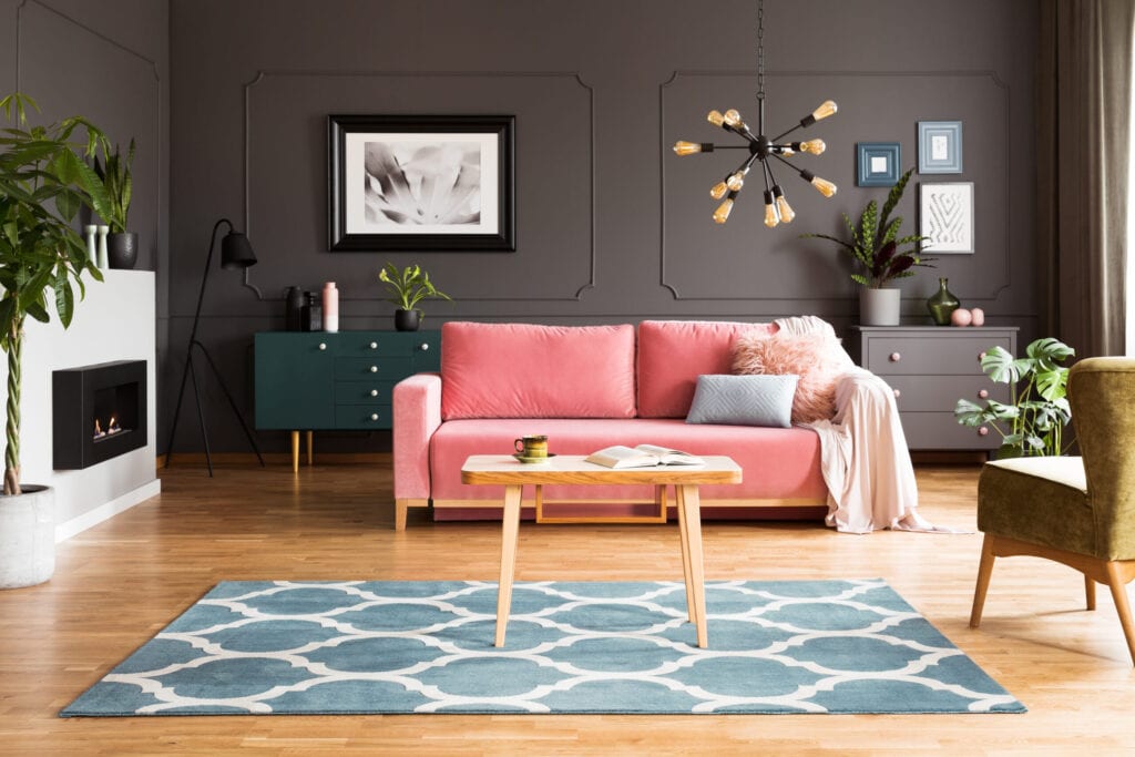 Grey interior of living room with pink sofa