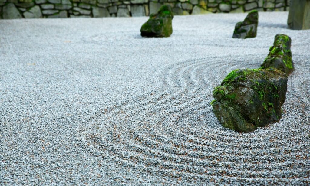 Japanese style rock garden with moss-covered rocks and sand