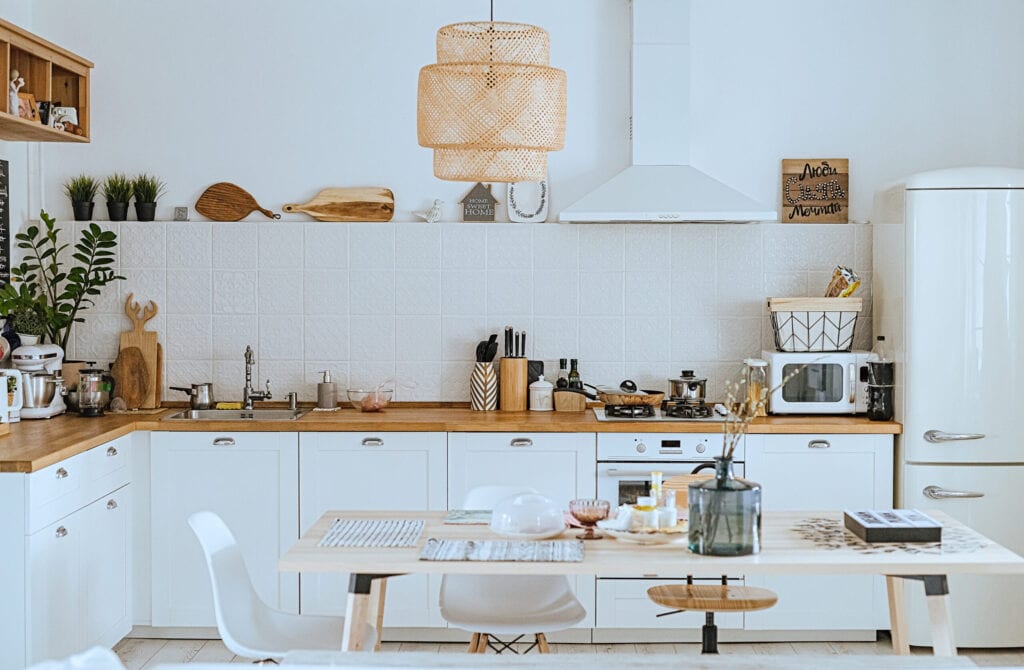 Scandinavian style cozy modern kitchen interior with a dining zone, white modern interior, everyday still llife, stay at home coronavirus quarantine, chores