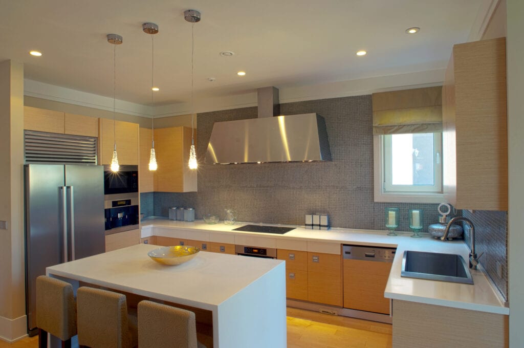 new luxury kitchen in a modern home mansion. A modern kitchen with granite counters, stainless steel appliances, and a tile backsplash.