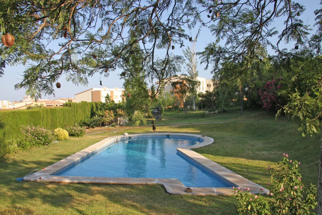 Gran piscina en un lujoso jardín.