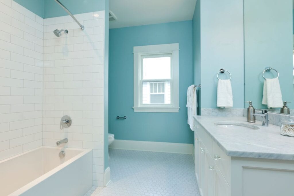 Clean blue bathroom with white subway tile shower