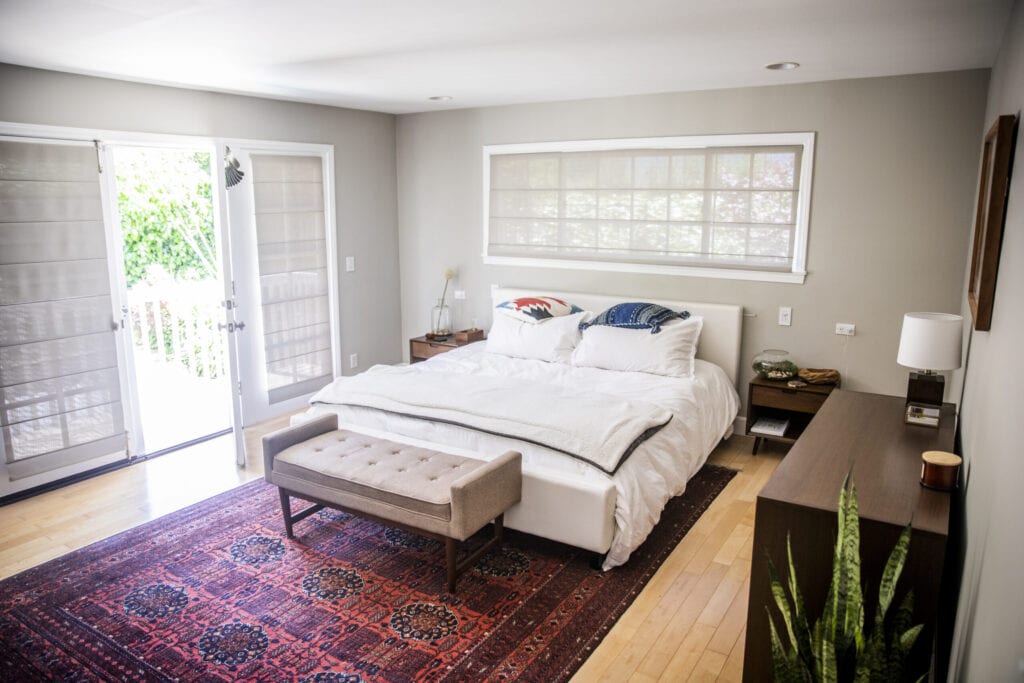 A master bedroom with a balcony door open