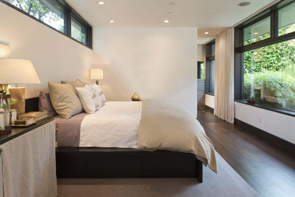 Modern style master bedroom with view of lush courtyard.