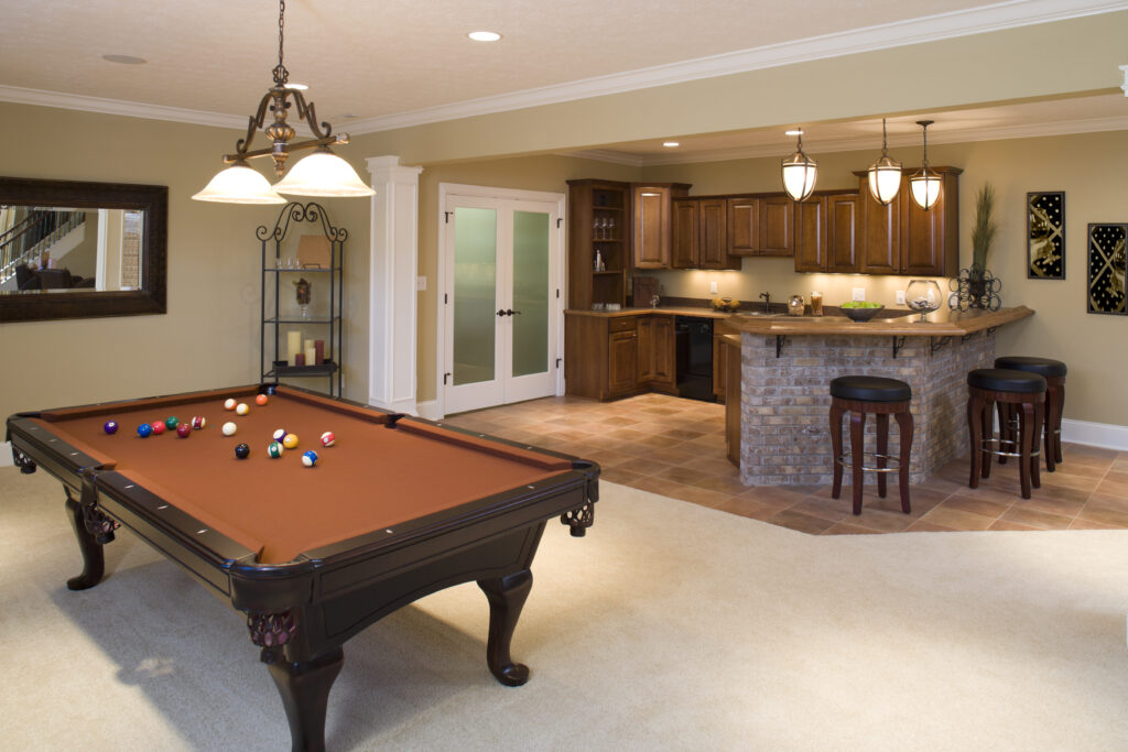Recently finished residential lower level game room and bar with pool table and stools.
