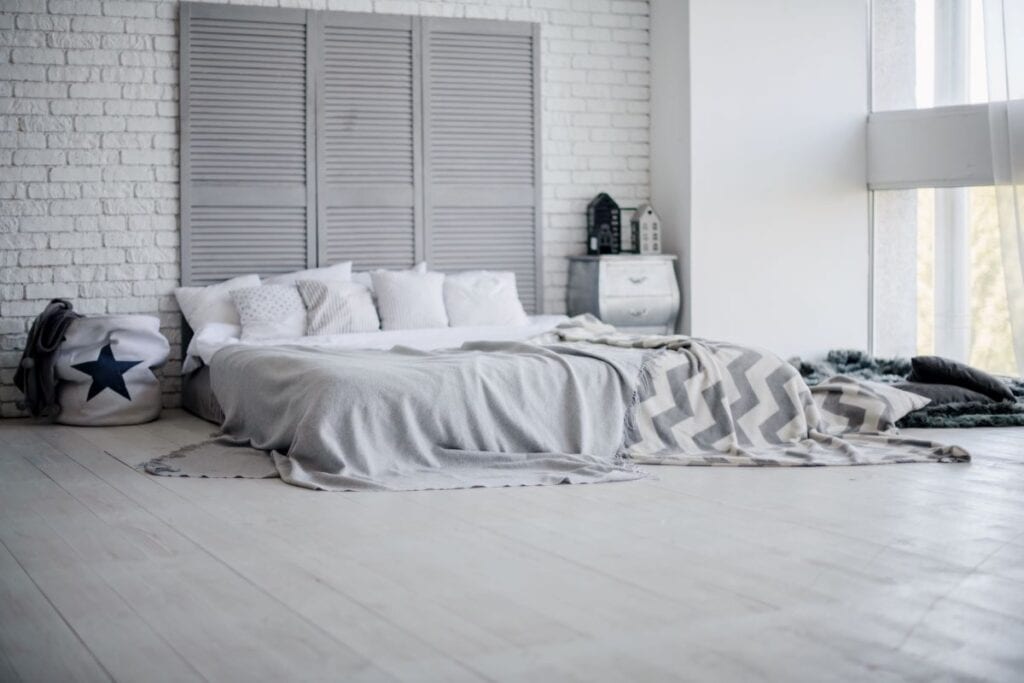 Dormitorio gris y blanco con cabecera creativa.