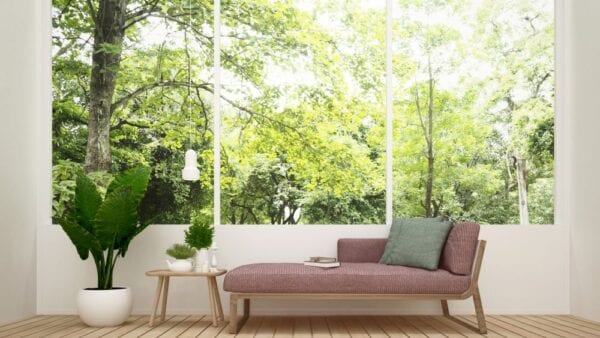 Pink daybed in front of large windows