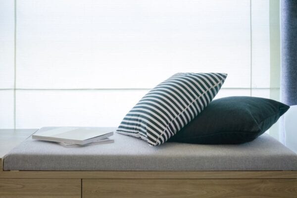 Wood daybed in window with pillows and open book