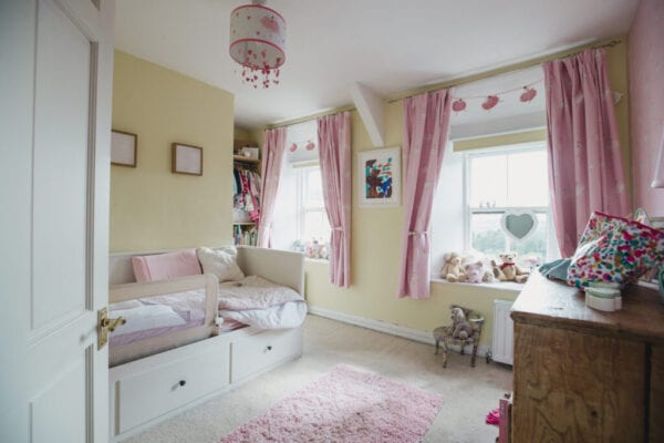 Feminine childhood bedroom with pink furnishings.