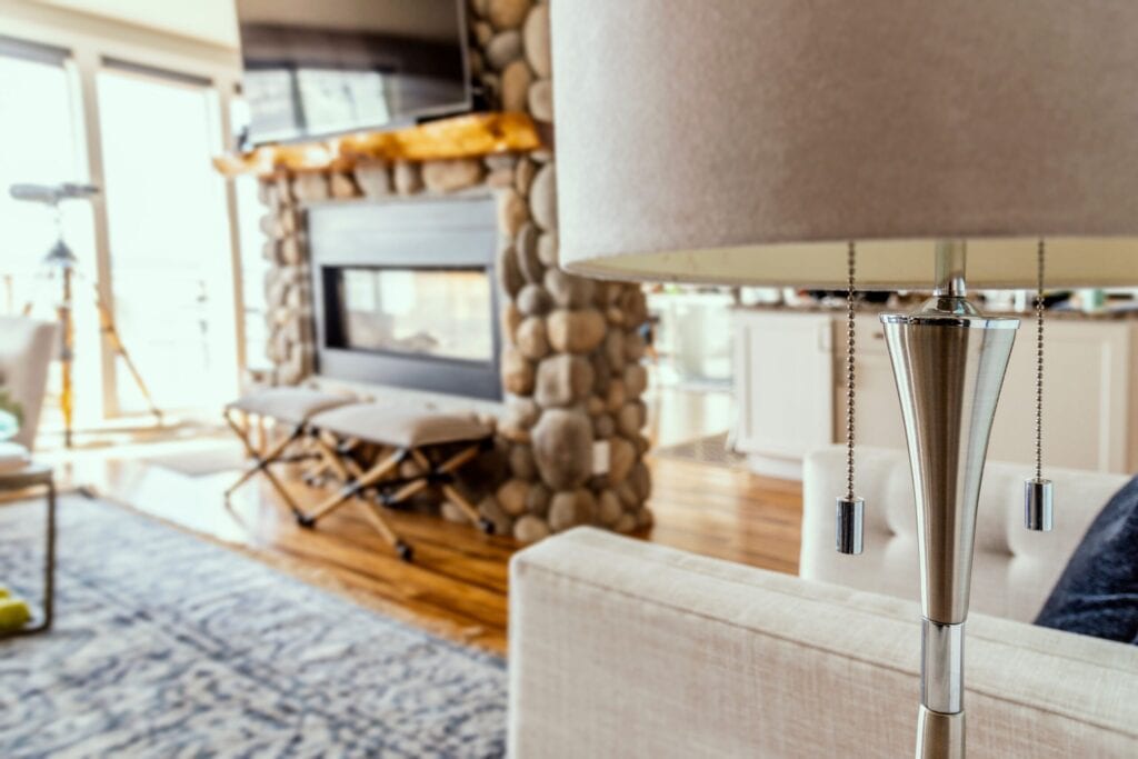 Close up photo of floor lamp, fireplace and tv in background