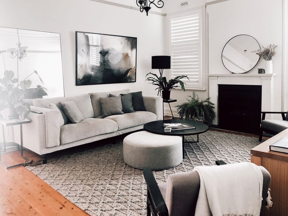 Modern black and white living room, art and mirror mounted on walls