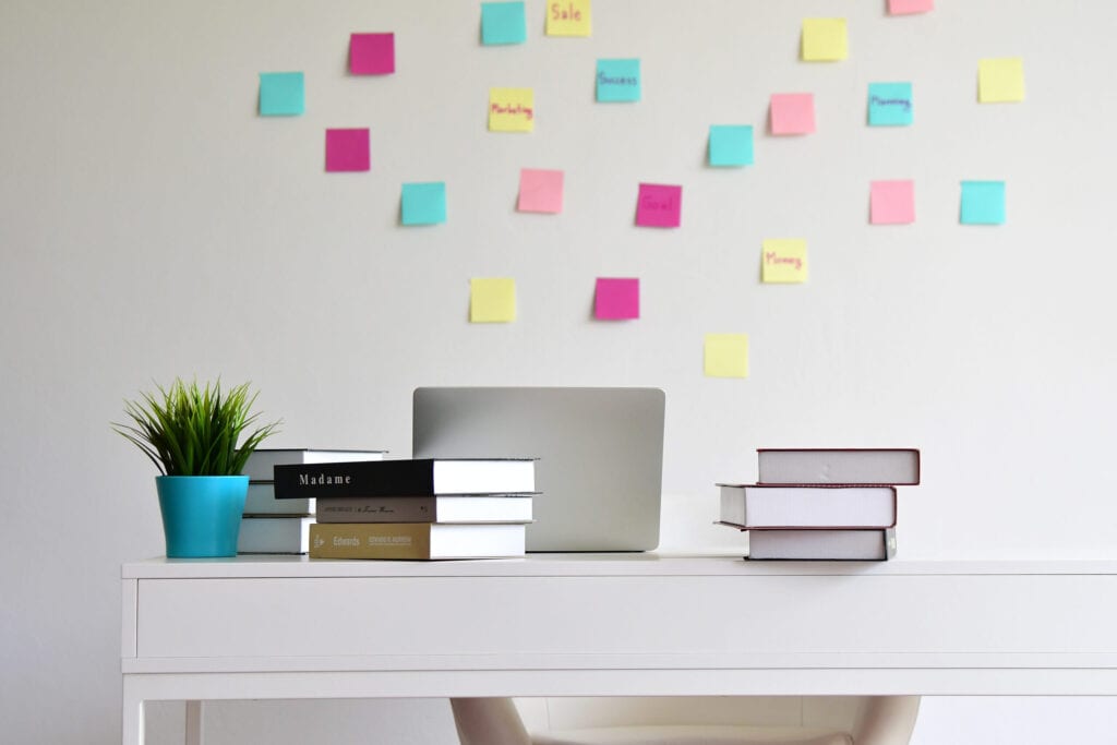 Modern Desk office with books stacked and computer laptop isolated over white wall background at home