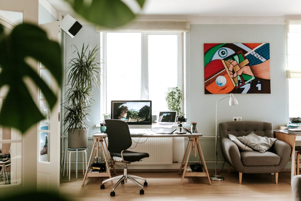 Photo series of a digital artist working at his home studio/office and doing video podcast while drawing a digital painting on a digital surface/tablet.