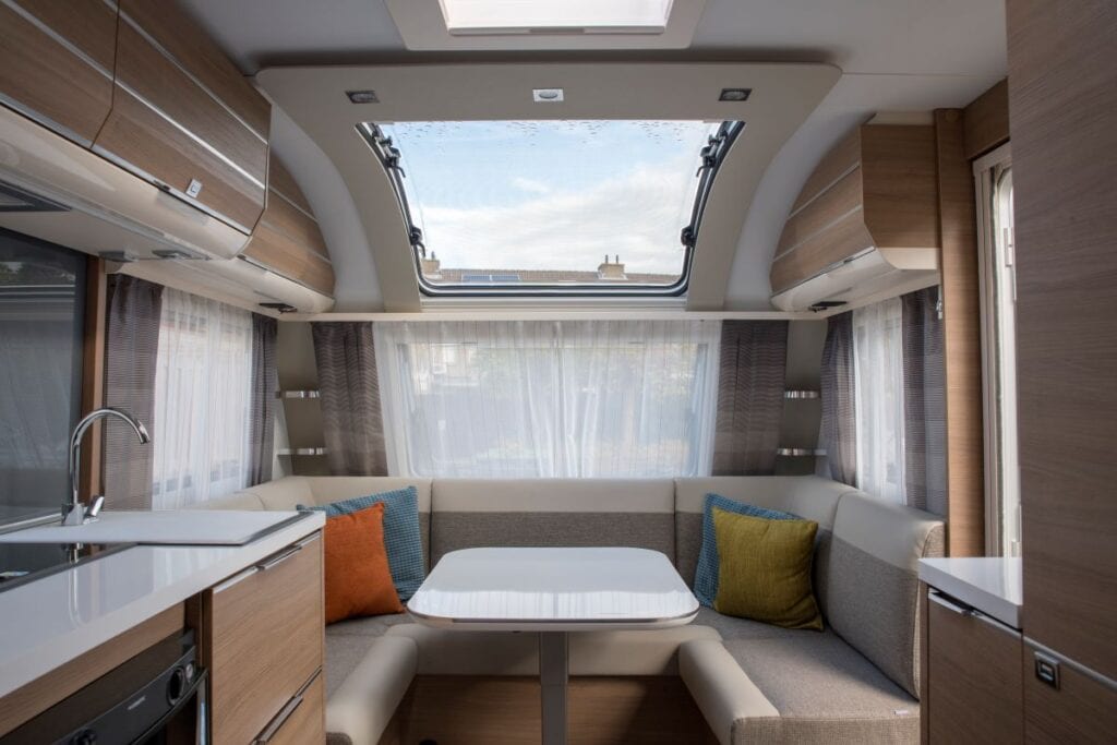 Camper van converted to workspace with natural light and wrap-around seating
