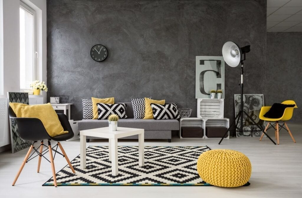 Black and white living room with yellow accents in the pillows and chair