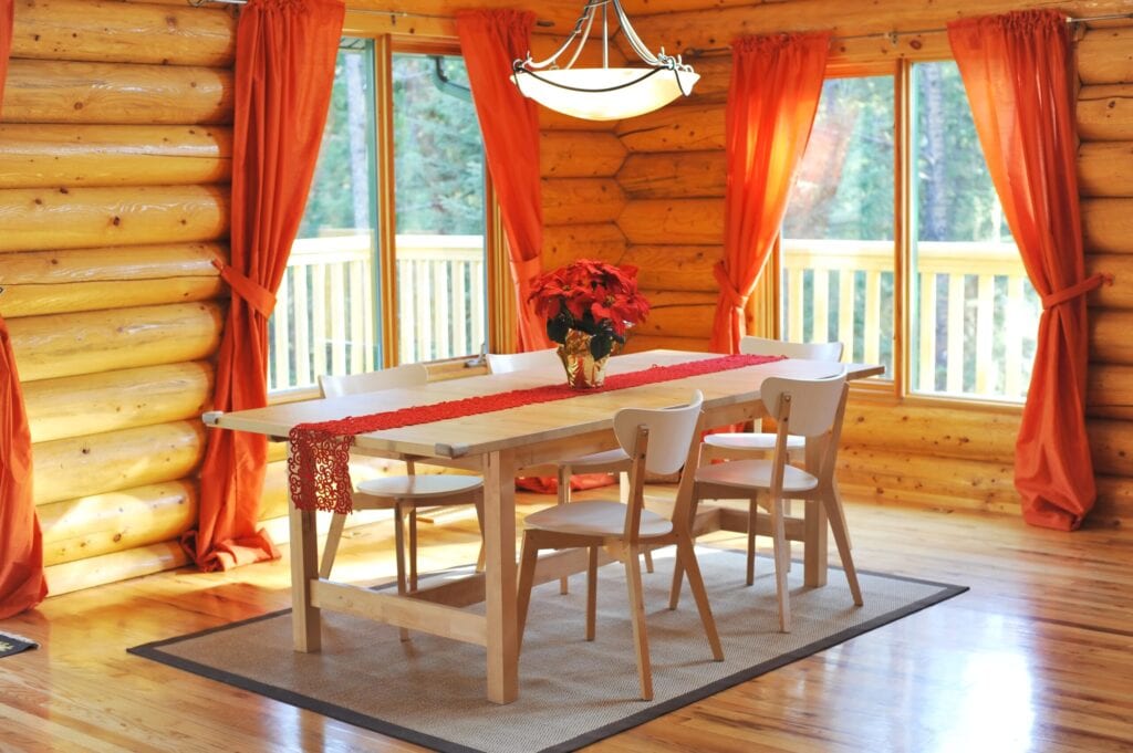 Dining room with hardwood floor in a Candian rustic log house.Outside a wrap-around deck,Canada.