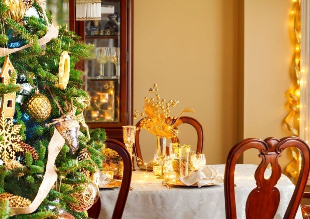 Christmas tree next to dining table with mustard yellow accents