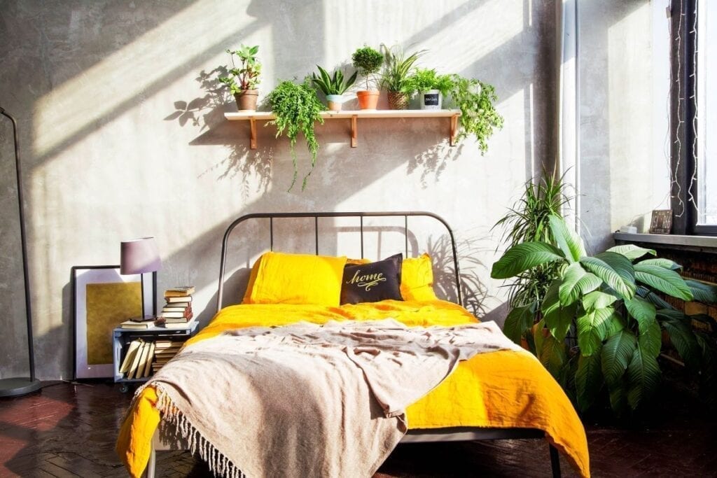 Modern industrial bedroom with yellow quilt on bed