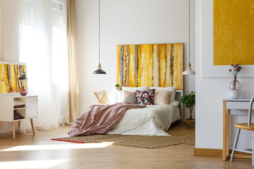 Spacious warm bedroom with contemporary artworks on the walls