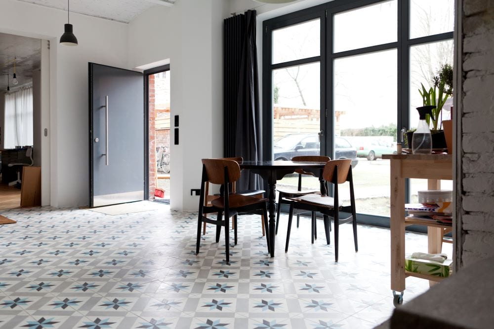 Modern dining room with large floor-to-ceiling windows and metal front door