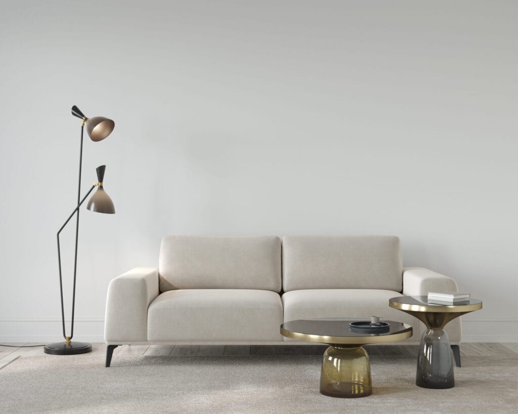 Living room or reception room interior in beige color, with a soft sofa, stylish floor lamp and glass tablesr