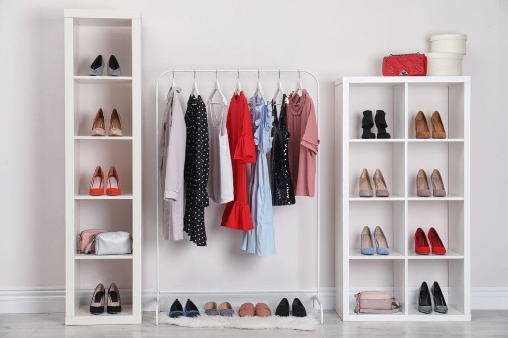 Clothes and shoes stored outside closet on rack and shelves