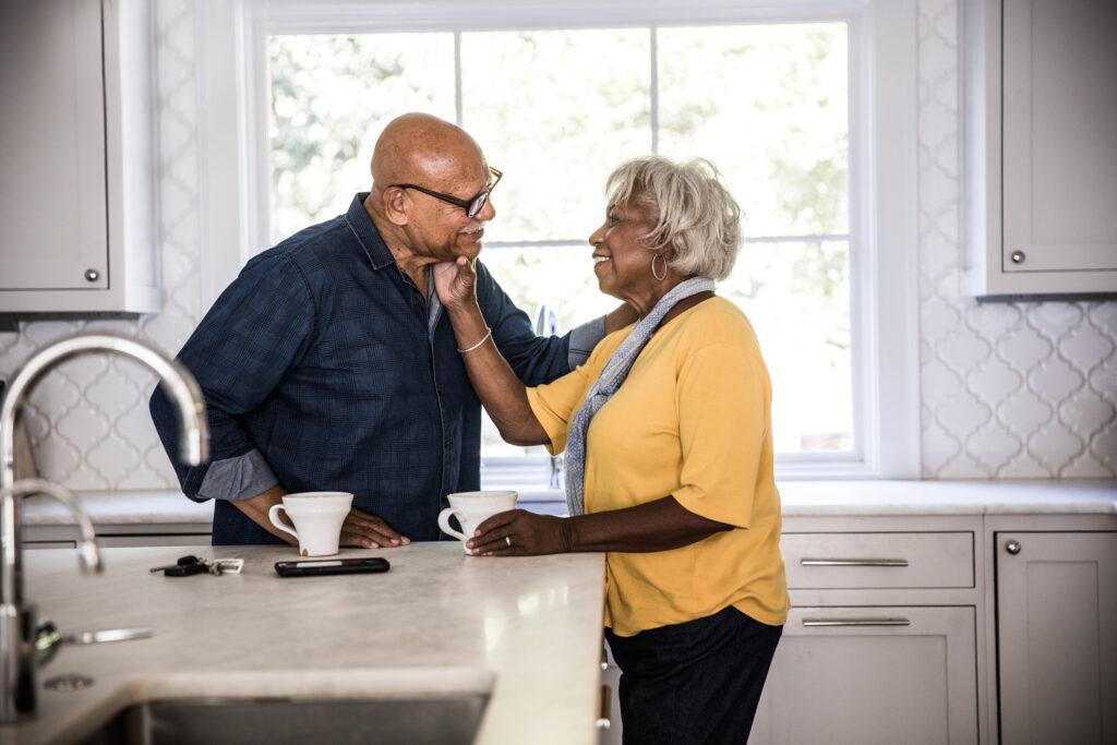 Older couple enjoys coffee in their kitchen.