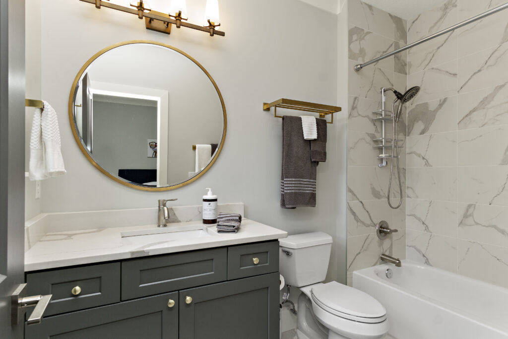 This images shows a modern bathroom with all new white paint and new marble tiles.