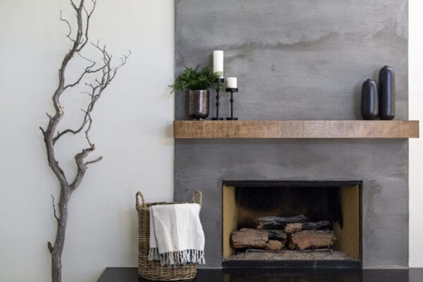 Modern gray textured fireplace with basket and tree branch